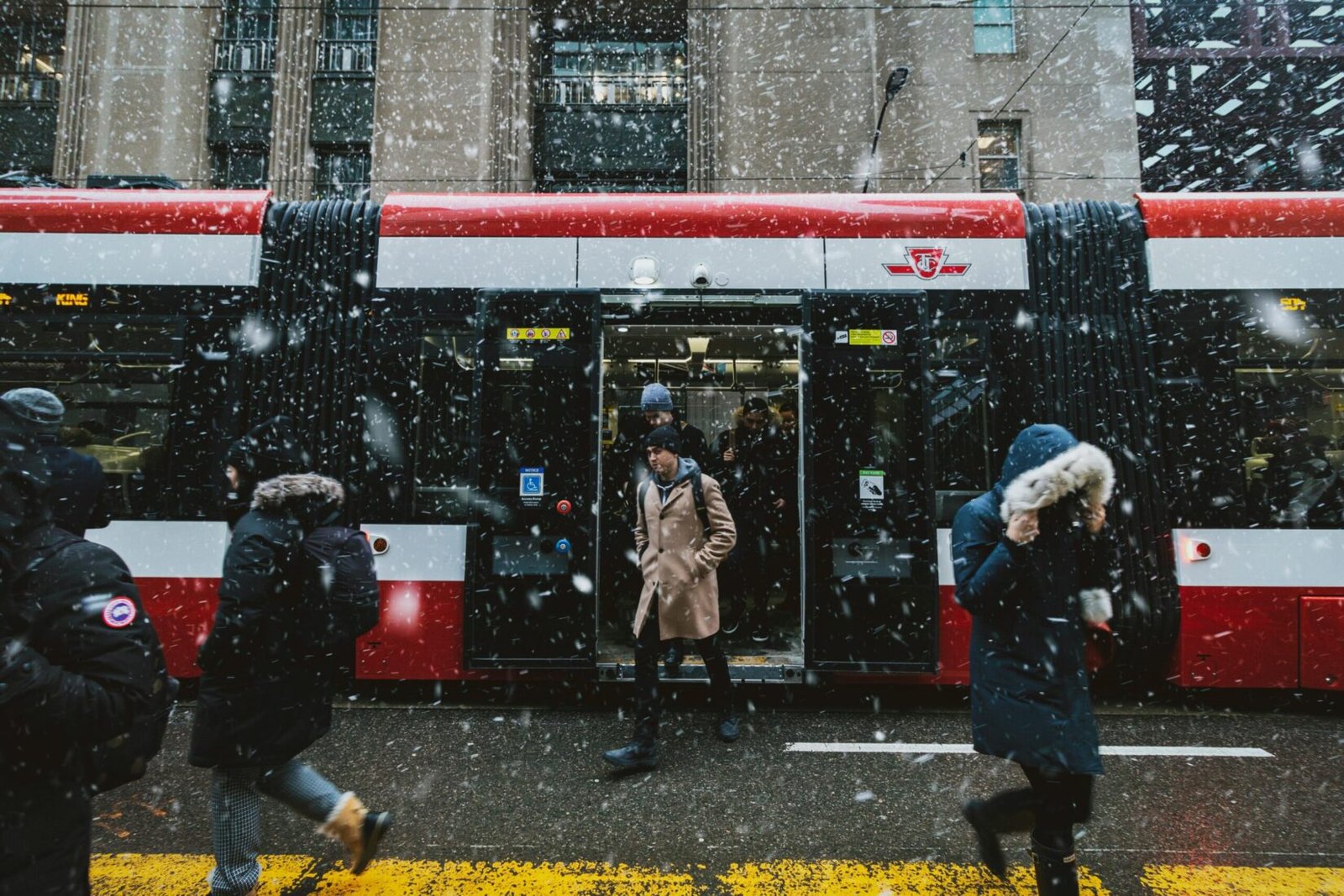 People commuting on a Toronto street during winter snowfall