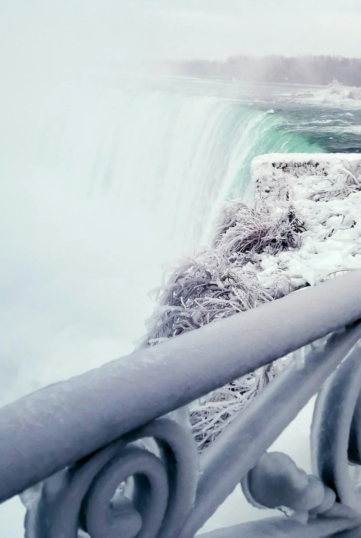 Niagara Falls in winter with frozen railings beside Horseshoe Falls